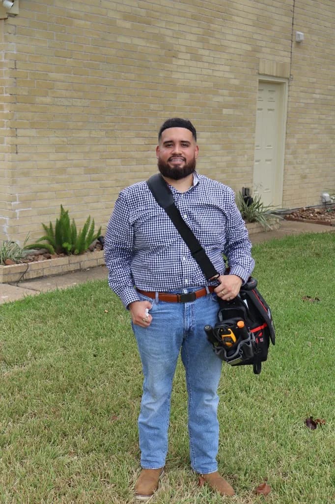 Luis Salas standing outside a home with an inspection tool bag